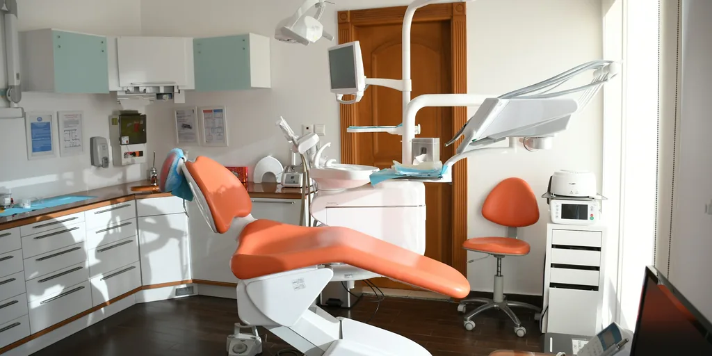 Bright dental operatory with a coral treatment chair